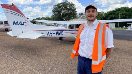 Erwin Jungen posing in front of a plane at the Mareeba Training Centre