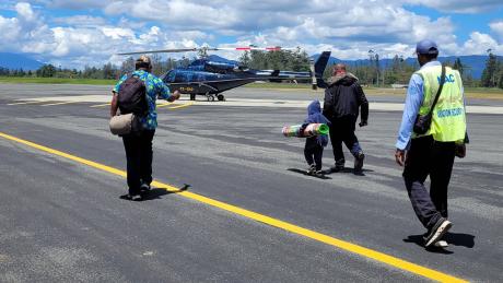 Governor Wenge (middle right) walking with Yaoum Sani (middle left) to board the Manolos Aviation flight home.