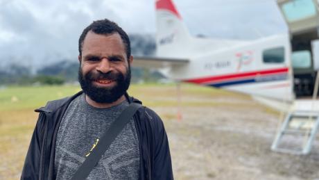 Justin Petrus, a teacher at Eliptamin after arrival in Telefomin posing in front of the MAF plane