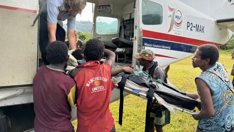 medevac patient on stretcher gets loaded into the aircraft