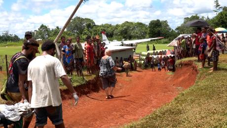 a patients being carried to the MAF plane at Mougulu