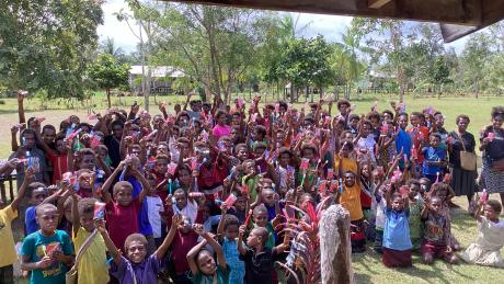 Group of happy Children raising toothpase packages up in the air