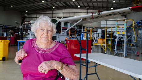 Elderly lady in aircraft hangar
