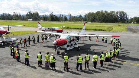 MAF's new Cessna Caravan P2-AFD arriving in PNG and surrounded by MAF staff in a prayer circle