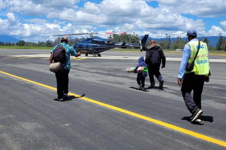 Governor Wenge (middle right) walking with Yaoum Sani (middle left) to board the Manolos Aviation flight home.