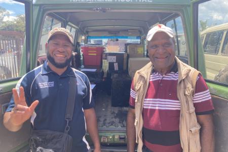 Issac Kaupa and Joe Korim are standing in front of their car filled with medical supplies