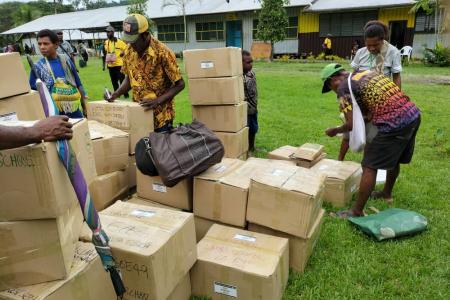 Boxes full of Bilum Books delivered by MAF being sorted.