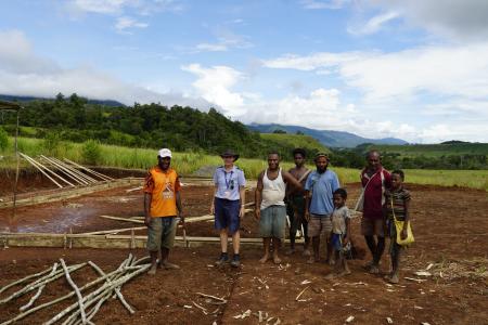 MAF Pilot Bridget Ingham with Mamusi missionary Andrew Gee, contractors, and Mamusi locals at the site of the new church.