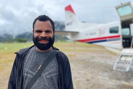 Justin Petrus, a teacher at Eliptamin after arrival in Telefomin posing in front of the MAF plane
