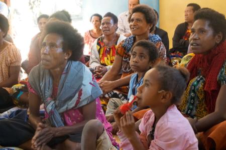 A group of women and girls listen to training