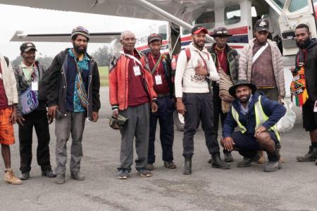 Passengers standing beside a plane