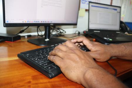 Hands working on a computer desktop
