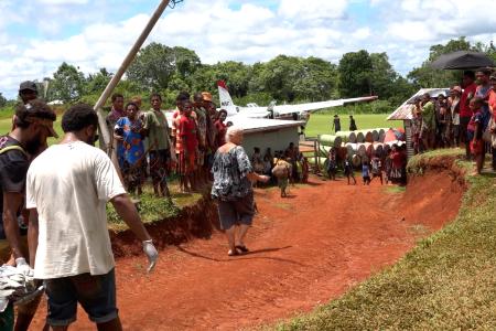 a patients being carried to the MAF plane at Mougulu