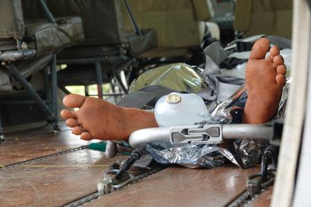 medevac patient on stretcher gets loaded into the aircraft but only with the feet visible