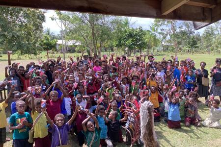 Group of happy Children raising toothpase packages up in the air