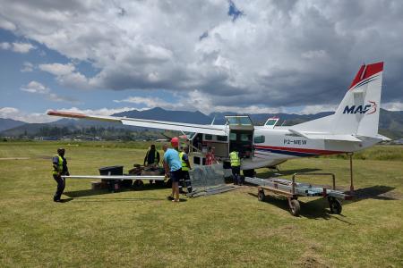 MAF plane on the ground in Goroka with playground materials loaded