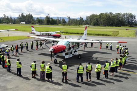MAF's new Cessna Caravan P2-AFD arriving in PNG and surrounded by MAF staff in a prayer circle