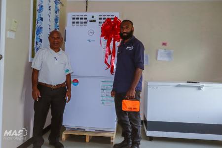 MAF Technologies technician Steven Zato guiding a health worker on the safe use of a solar-powered vaccine fridge.