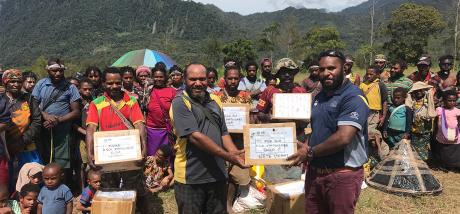 Miok Michael handing over the stationary donations to the school’s teachers