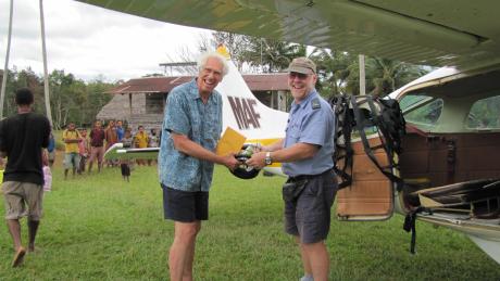 2010 MAF pilot Mike Botrell delivering lown mower parts to Dan Shaw at Honinabi