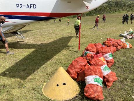 bags of sweet potatoes lined up o be loaded into the aircraft at Wobagen