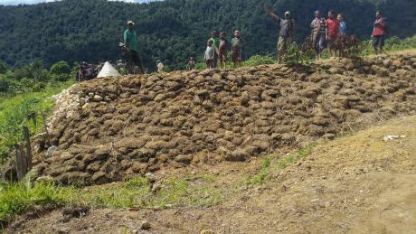 Dimanbil villagers stand atop a retaining wall they constructed for the airstrip.