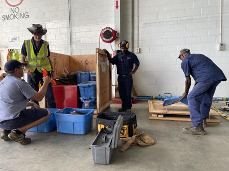 Tim Neufeld and three other work men unpacking the various boxes and tools 