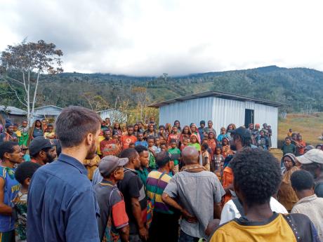 Locals of Norambi gathering to help MAF Tech officer, Julian Wolf to initiate the HF radio installation