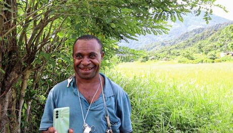 A man smiling holding a phone