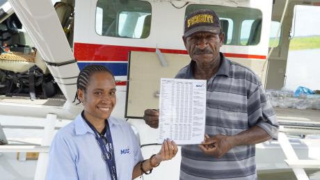 Diana Puri giving air fares to Kusikina MAF Agent