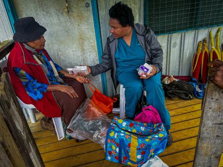 Dr. Carolyn providing medical care to a patient in a rural community of Papua New Guinea.