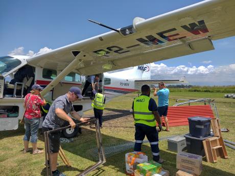 Goroka staff loading playground unto MAF plane