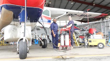 Matt Kaye and Jade Kunika with the compressor rinse equipment in the hangar