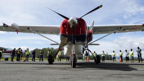 MAF's new Cessna Caravan P2-AFD arriving in PNG and surrounded by MAF staff in a prayer circle