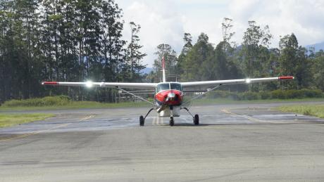 MAF's new Cessna Caravan P2-AFD arriving in PNG and surrounded by MAF staff in a prayer circle