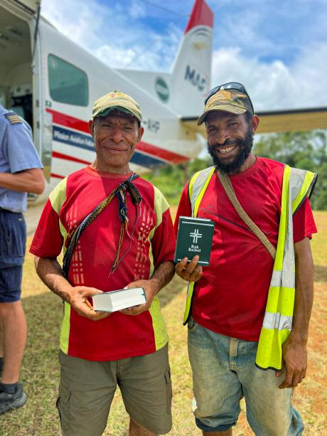 Two men smiling holding Bibles