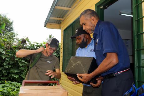 A man picks up a box of Bibles from a supplier