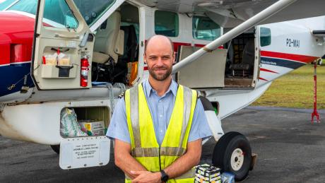 Andy Little standing in front of MAF plane before departure